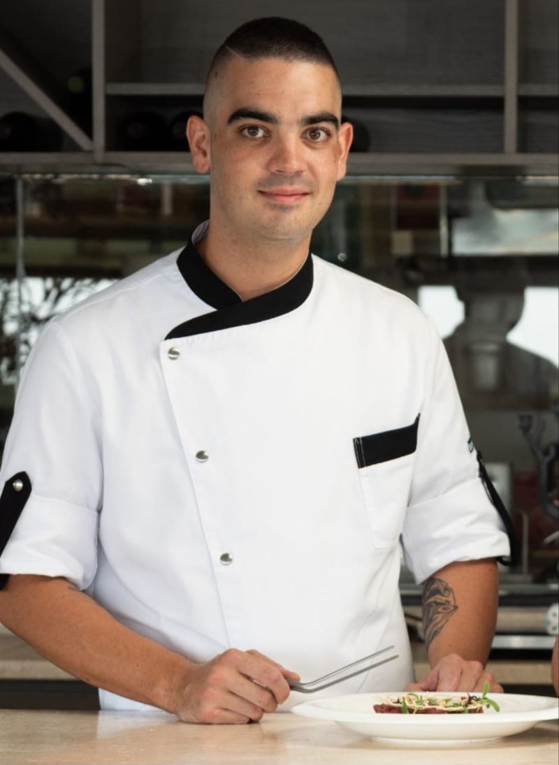 Francesco Cappai, chef e fondatore di Catering su Misura, mentre rifinisce un piatto in cucina