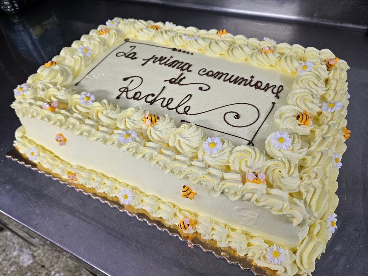 Torta da prima comunione con ciuffi di crema al burro, margherite e apette in pasta di zucchero
