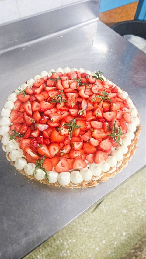 Millefoglie tonda ricoperta di fragole fresche e ciuffi di crema