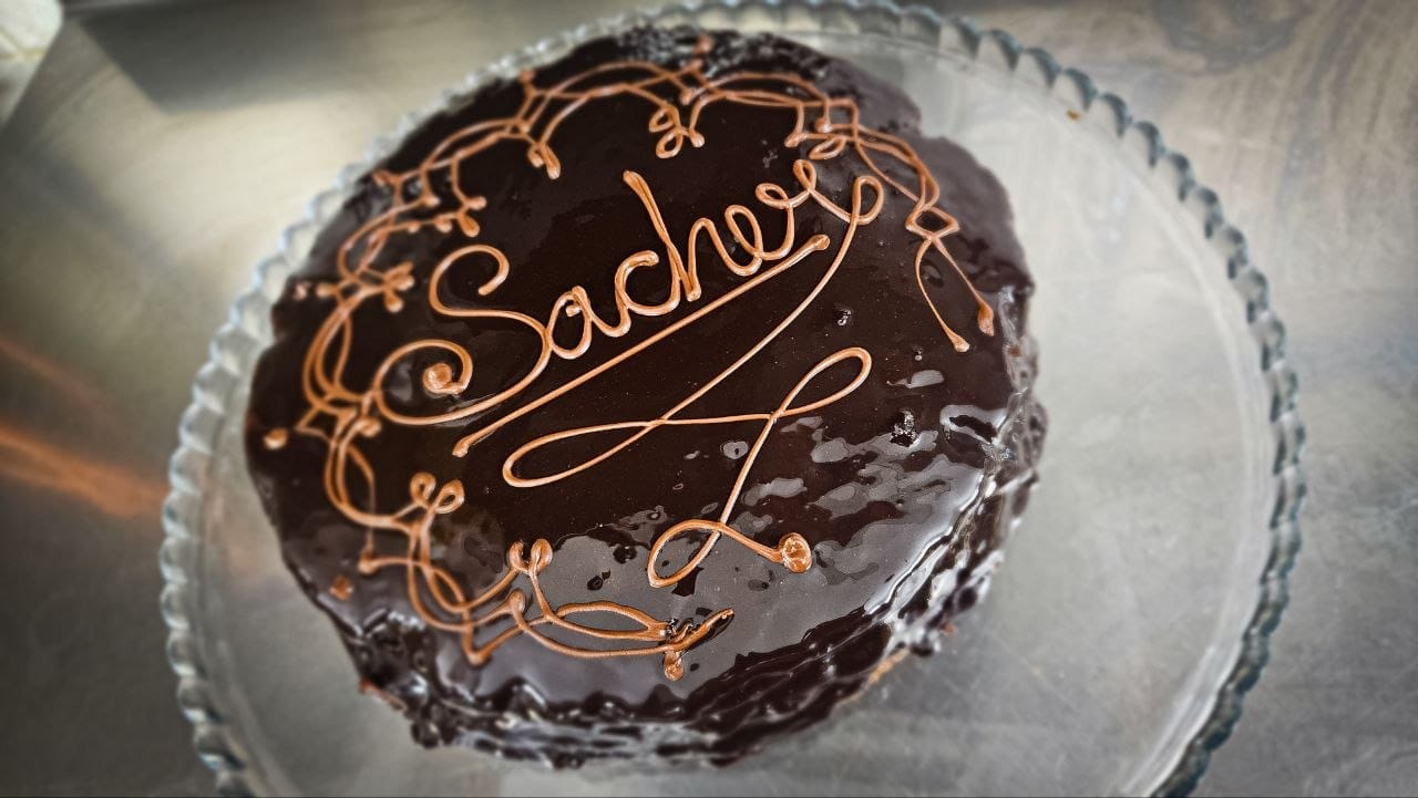 Torta Sacher glassata al cioccolato con scritta e decori a cornetto