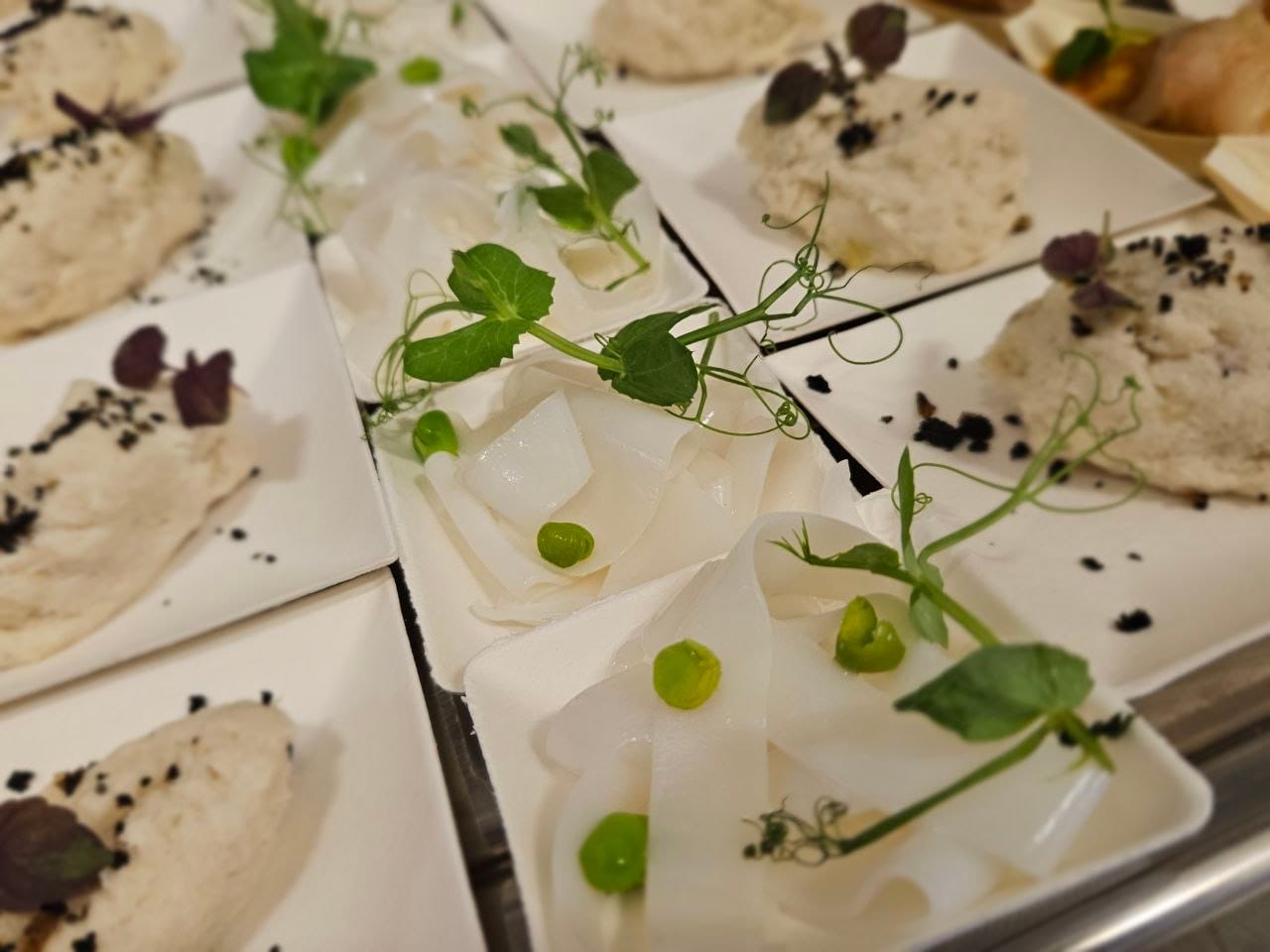 Piattini di baccalà mantecato e carpaccio di seppia con germogli di pisello e polvere di olive