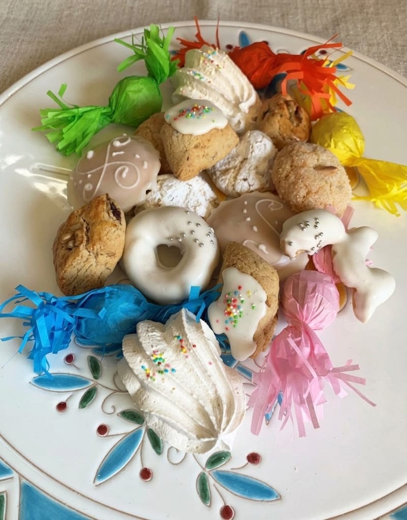 Piatto di dolci sardi: amaretti, pabassinas glassate, meringhe e caramelle incartate a festa