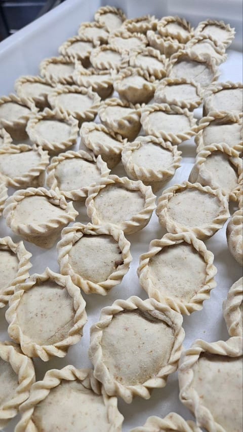Panadine tonde con il bordo intrecciato a mano, pronte per il forno